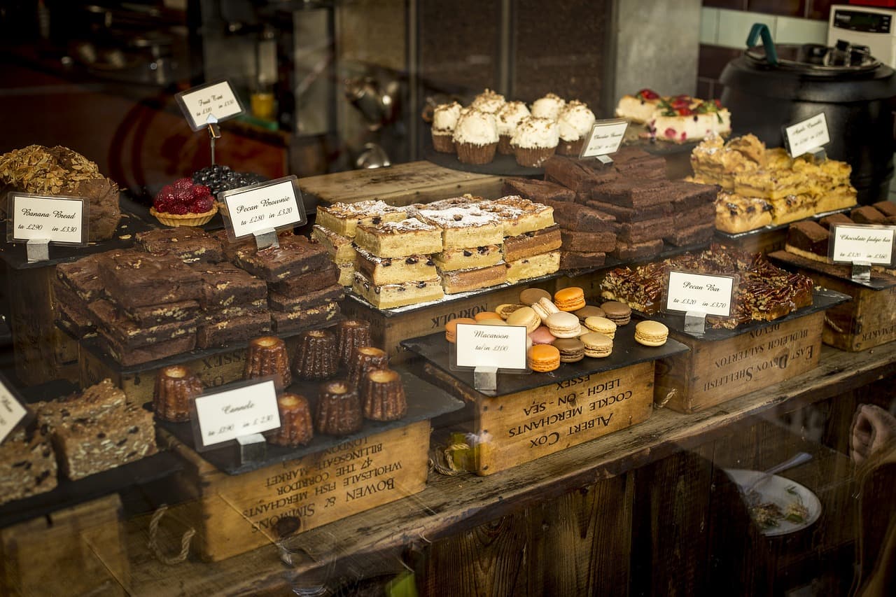 A cafe counter of brownies and cakes with handwritten labels