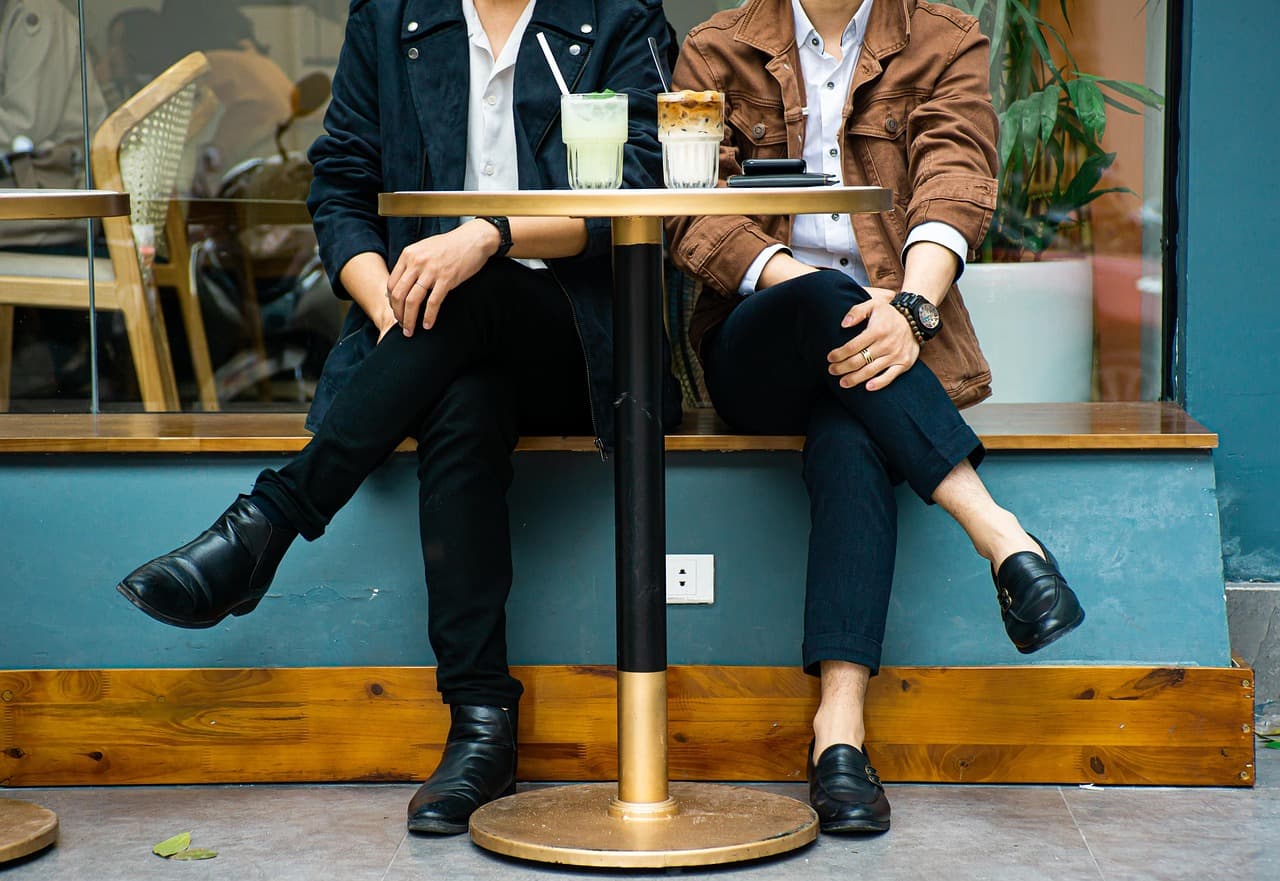 Two people sitting at a small cafe table by a window